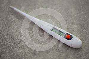 Close-up electronic thermometer for measuring body temperature on a gray background