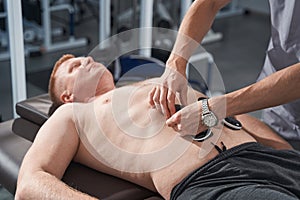 Close up electrostimulator on man stomach. Myostimulation therapy