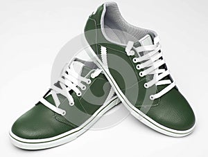 Close up of elegant dark green sports shoes in natural  leather for adult men photographed on a white background. Fashion