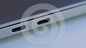 Close up of elegant modern laptop details. Action. Concept of modern technologies, USB port of a computer lying on white