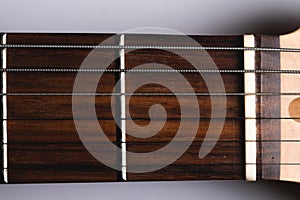 Close-up elements of electric guitar on gray background