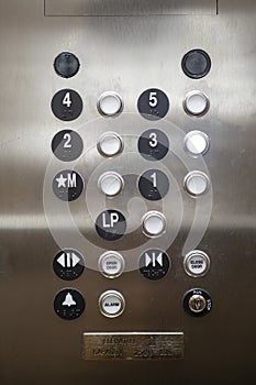 Close-up of elevator control panel with numbered buttons and additional functions