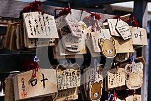 Close up Ema are small wooden plaques, common to Japan, in which Shinto and Buddhist worshippers write prayers or wishes.