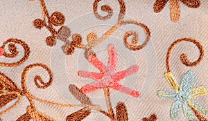 Close up on embroidered fabric with flowers.