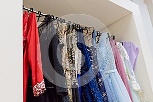 Close-up embroidered with stones and sequins top pink wedding dress which hangs on a hanger among other dresses. glamour