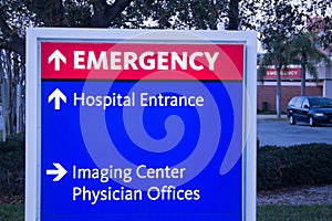 Close up -Emergency center sign with hospital in background