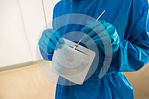 Close-up of emergency doctor putting a swab into a plastic bag in hospital