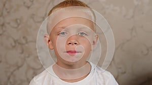 A close-up of an emotional boy shows his fallen baby tooth, he moves his tongue.