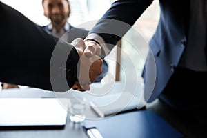 Close up employer shaking successful candidate hand at meeting