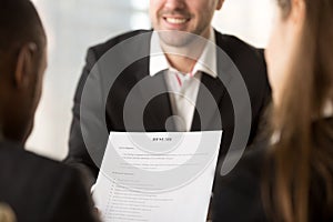 Close up of employers or recruiters holding reviewing cv resume