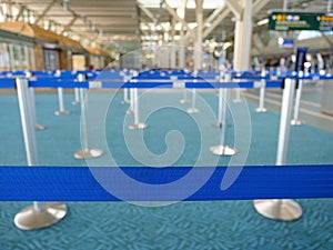 CLOSE UP: Empty baggage drop lines inside a bright international airport.