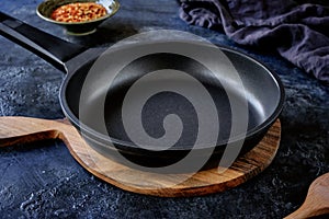 Close-up of an empty black non-stick frying pan on a beautiful dark background