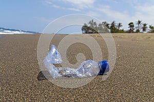 Close-up empty bottle plastic garbage on the sea beach