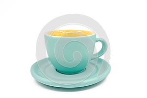 Close-up of empty cyan cup with cyan plate. Yellow colour inside of the coup.