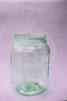 Close up of empty glass jar or storage jar or glass container isolated on pink surface