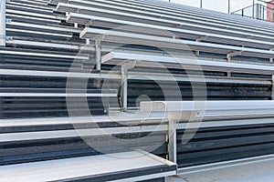 Close-Up of empty metal stadium bleacher seats along aisle with steps.