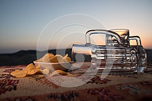 Close up empty mugs of beer on a sunrise background with mountains. Beer party is over concept.