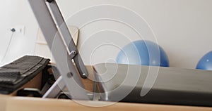 Close up of empty pilates rehabilitation room with reformer and exercise balls, slow motion