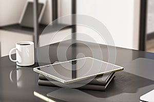 Close up of empty tablet with reflections, coffee cup and other items on outdoor workplace table with sunlight.