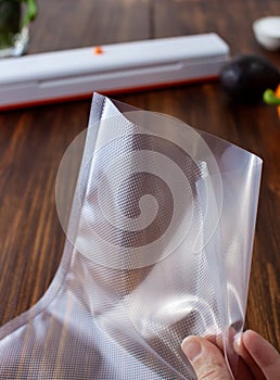 Close-up of an empty vacuum bag with different textures in a woman`s hand