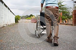 Close up empty wheelchair with man hands.