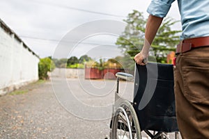 Close up empty wheelchair with man hands.