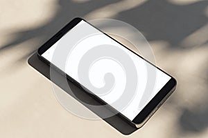Close up of empty mobile phone on light surface with leaf shadows. Presentation concept. Mock up, 3D Rendering