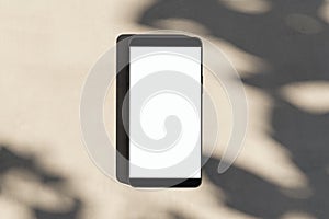Close up of empty smartphone on light surface with leaf shadows. Presentation concept. Mock up, 3D Rendering