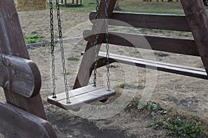 Close-up of an empty wooden swing in the playground
