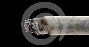 Close up of the end of a lit cigarette slowly burning and turning to ash