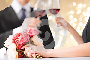 Close up of engaged couple drinking red wine