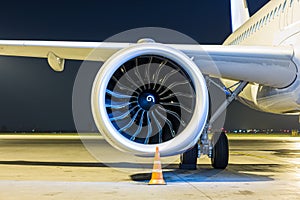 Close-up of engine of big white passenger jet plane at night