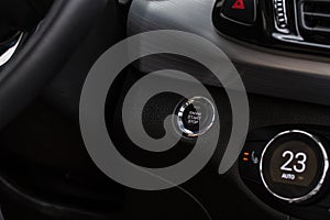 Close up engine car start stop button. Modern car black interior details.