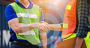 Close up of engineer and foreman worker handshake with blurred construction site, Success and Teamwork concept