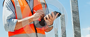 Close-up, engineer manager using tablet, building, construction site. inspecting and working at construction site. banner image