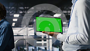 Close up of engineer using green screen mockup tablet in data center