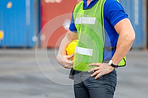 Close up of Engineer, worker man holding hard hat at cargo containers