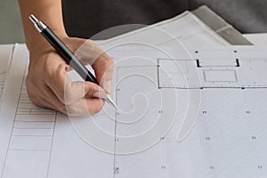 Close up of engineers hands working on table, he drawing project sketch in construction site or office.