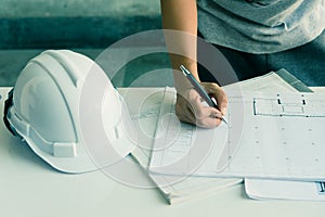 Close up of engineers hands working on table, he drawing project sketch in construction site or office