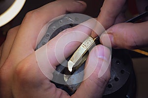 Close-up of engravers hands engraving on gold watch blank, handmade watch production order, watch custom order