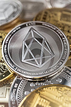 Close-up of eos physical coin on stack of many other cryptocurrencies
