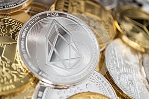 Close-up of eos physical coin on stack of many other cryptocurrencies photo