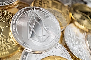 Close-up of eos physical coin on stack of many other cryptocurrencies