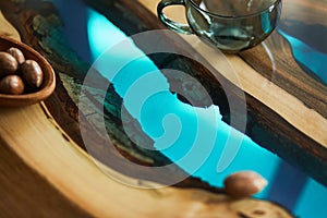 Close up of epoxy wooden coffee table with glass and nuts. Details. Texture.
