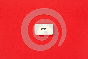 Close-up of an Escape symbol button on a vibrant red background