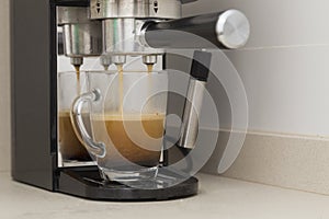 close-up of an espresso machine arm making coffee sleepy mornings