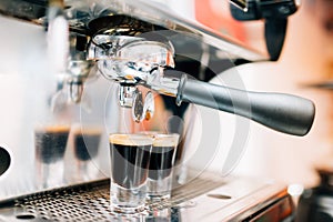 close up of espresso machine pouring fresh coffee into cups at pub