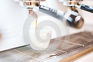 Close-up of espresso pouring from coffee machine. Professional coffee brewing