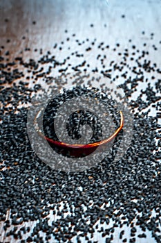 Close up of an essential beneficial ayurvedic herb i.e kalonji or black caraway in a wooden plate on a wooden surface in dark