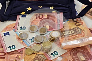 Close-up of euro bills and diy facemask, designed as an European Union flag.